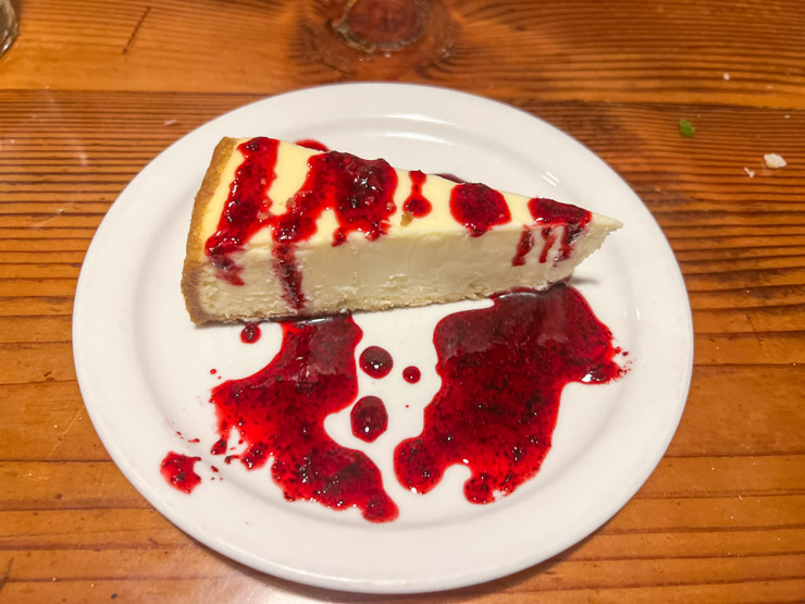 Plate with cheesecake with huckleberry sauce.